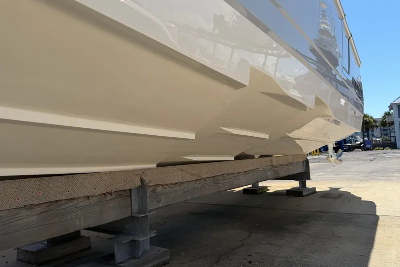 Slide: The Image of 2023 Robalo R360 Center Console boat hull on a wooden stand. - 2