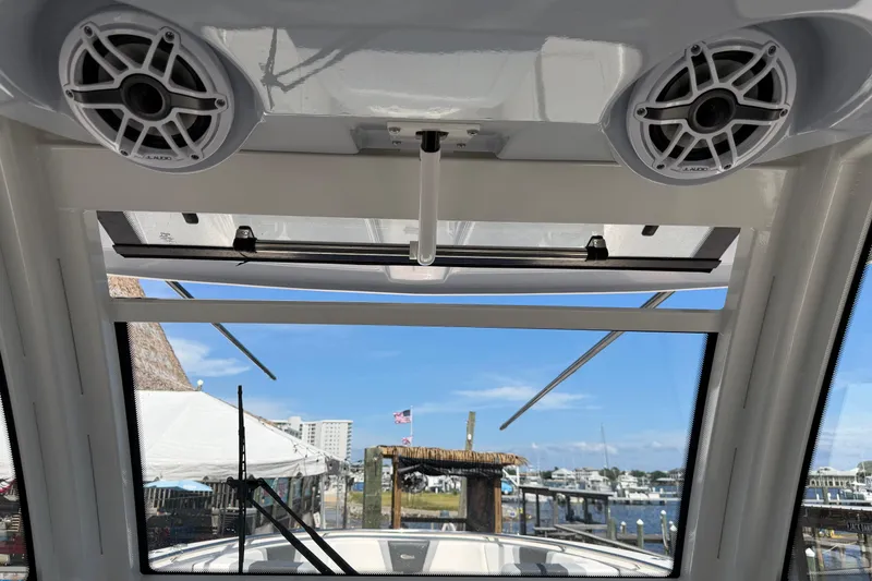 Slide: The Image of 2023 Robalo R360 Center Console boat interior with speakers and marina view. - 26
