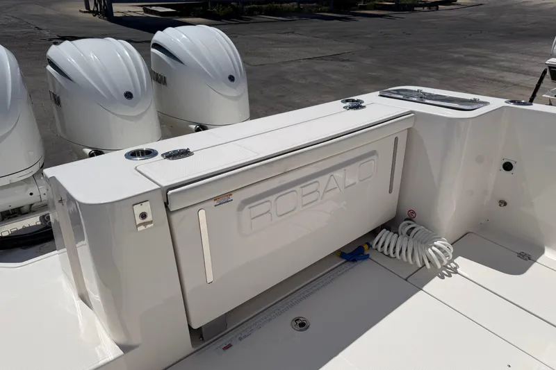 Slide: The Image of 2023 Robalo R360 Center Console boat with triple Yamaha engines, docked outdoors. - 7