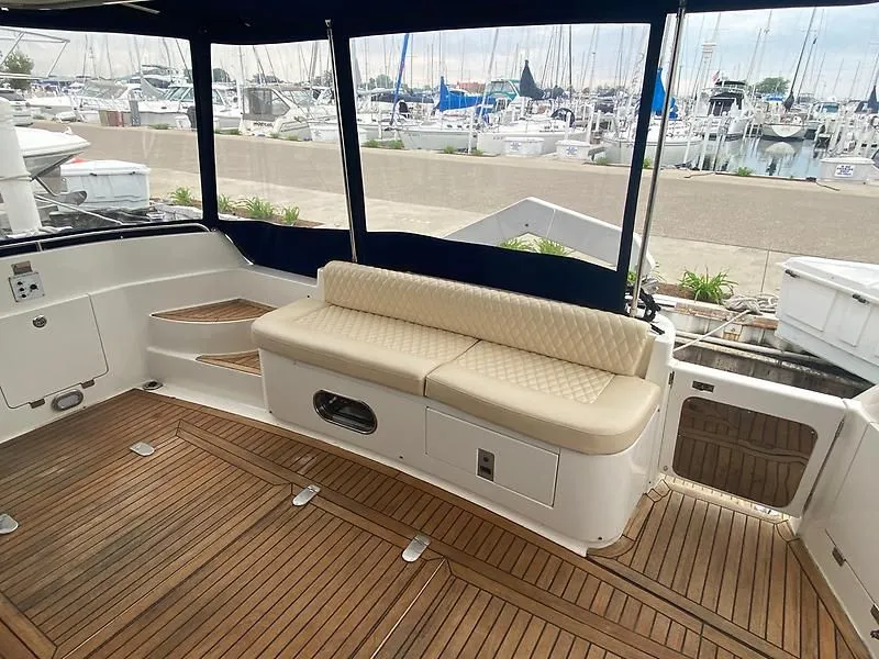 Slide: The Image of The image shows the cockpit of a 1998 Sunseeker Manhattan 62 with wooden flooring and cream-colored seating. - 10
