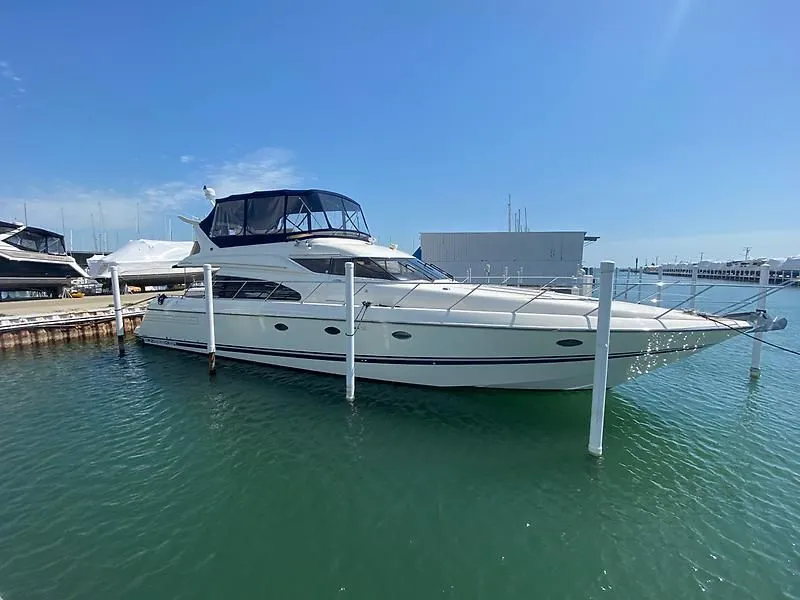 The Image of A 1998 Sunseeker Manhattan 62 is docked in the water. It features a sleek design. - 0