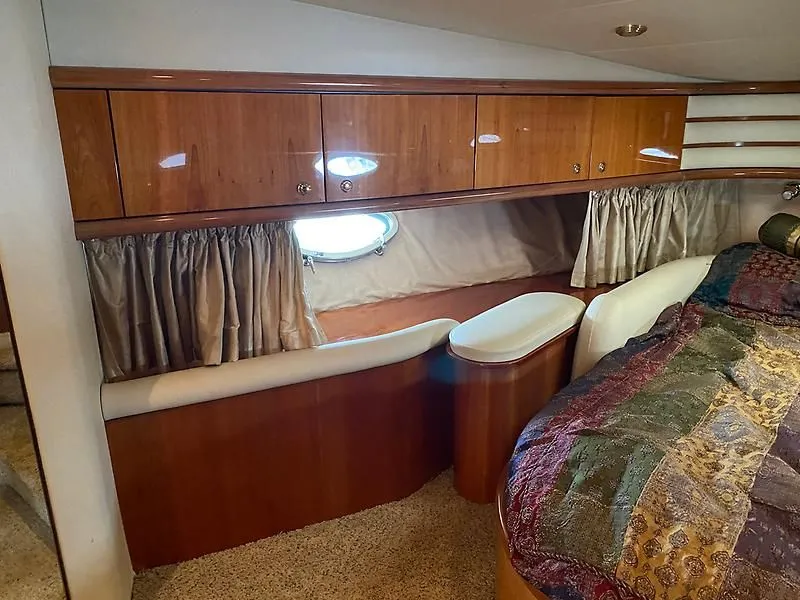 Slide: The Image of Interior of the 1998 Sunseeker Manhattan 62 with wood cabinetry and a porthole. - 32