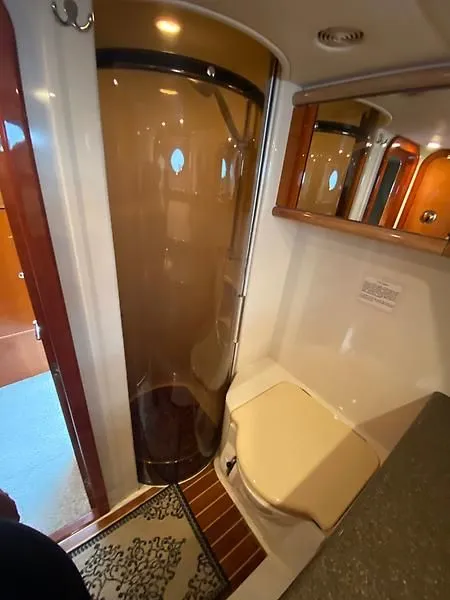 Slide: The Image of The image shows a bathroom on a 1998 Sunseeker Manhattan 62 yacht with a shower enclosure. - 38