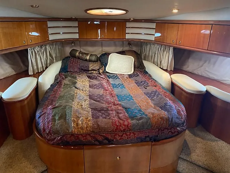 Slide: The Image of The 1998 Sunseeker Manhattan 62 cabin features a large bed with a colorful quilt, surrounded by wooden cabinets. - 31