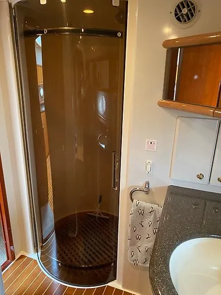 Slide: The Image of The image shows an elegant shower cabin on a boat, with wood details and a sink nearby. - 36