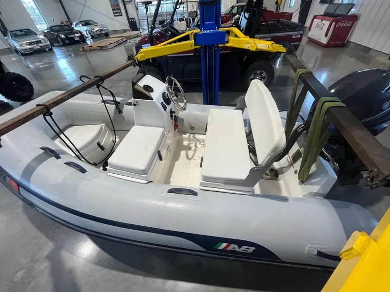 Slide: The Image of Inflatable boat in a garage, featuring white seating and steering console. - 36
