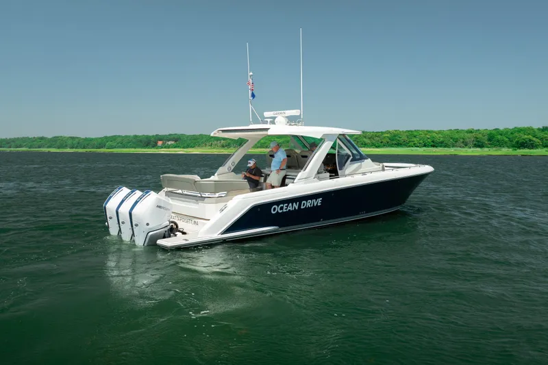 Slide: The Image of 2022 Tiara Yachts 38 LS cruising on water, featuring triple outboard engines. - 2