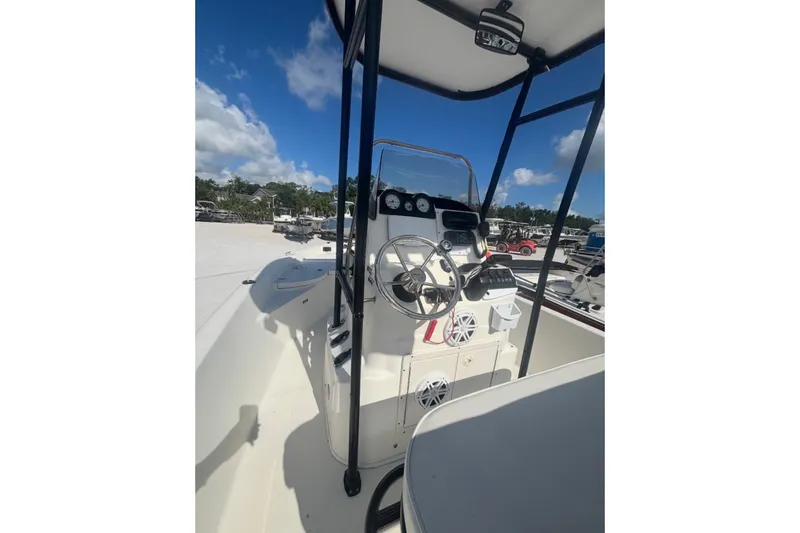 Slide: The Image of 2017 NauticStar 1910 NauticBay boat interior with steering wheel and controls under a clear blue sky. - 2