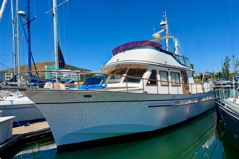 Slide: The Image of 1981 Kha Shing Sundeck ACMY yacht docked in a marina under clear blue skies. - 58