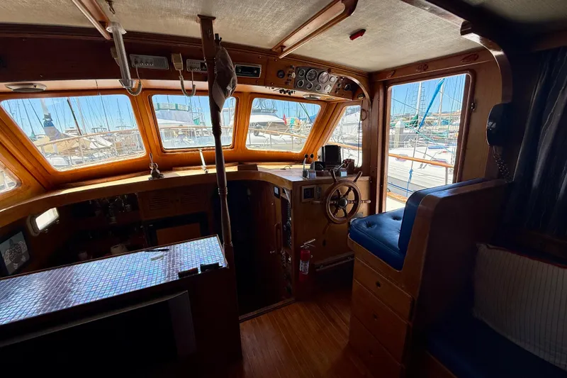 Slide: The Image of Interior of 1981 Kha Shing Sundeck ACMY yacht with wooden helm and marina view. - 5