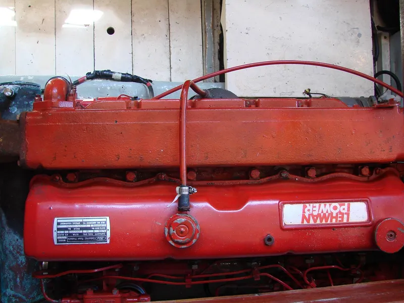 Slide: The Image of A red engine in a boat, surrounded by metal parts and cables. - 30