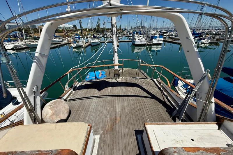 Slide: The Image of 1981 Kha Shing Sundeck ACMY yacht docked in a marina, surrounded by sailboats. - 52