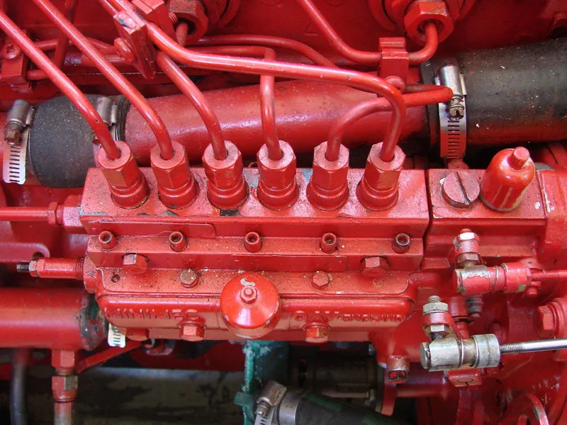 Slide: The Image of Close-up of a red engine with multiple hoses and valves. - 38