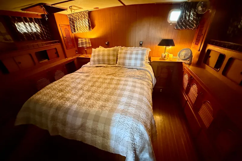 Slide: The Image of Cozy bedroom interior of 1981 Kha Shing Sundeck ACMY yacht with wood paneling and soft lighting. - 15