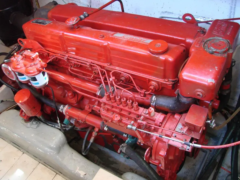 Slide: The Image of A red marine engine with visible cables and hoses in an engine room. - 32