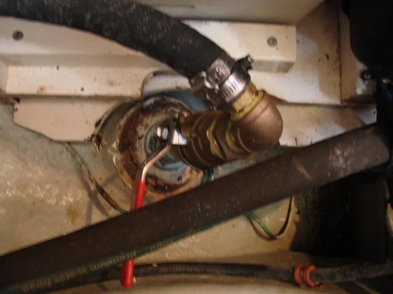 Slide: The Image of A valve with a red lever handle in an engine room, surrounded by hoses and wires. - 39