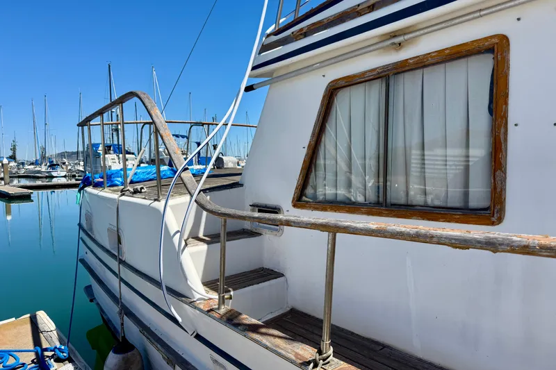 Slide: The Image of 1981 Kha Shing Sundeck ACMY yacht docked at marina, showcasing side view and window details. - 47