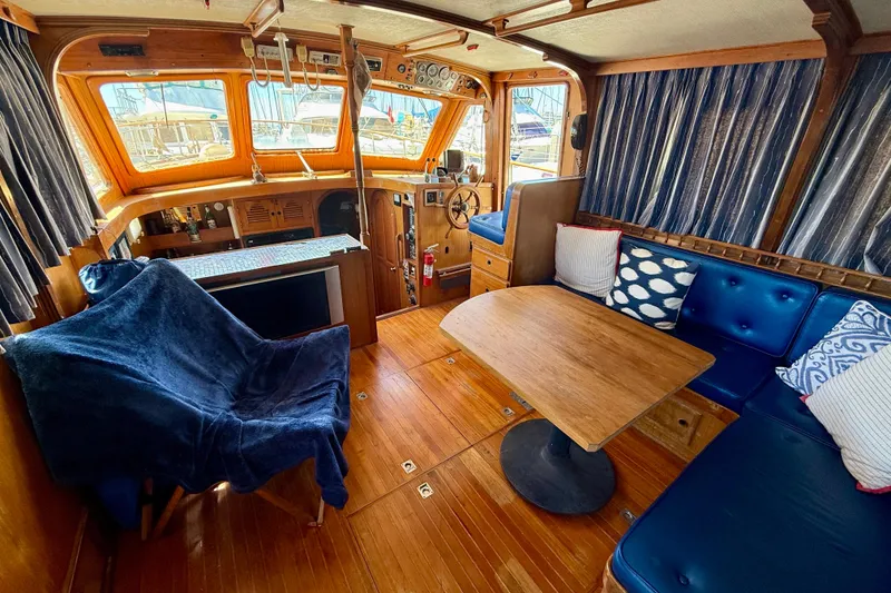 Slide: The Image of 1981 Kha Shing Sundeck ACMY interior with wooden decor, blue seating, and nautical accents. - 4