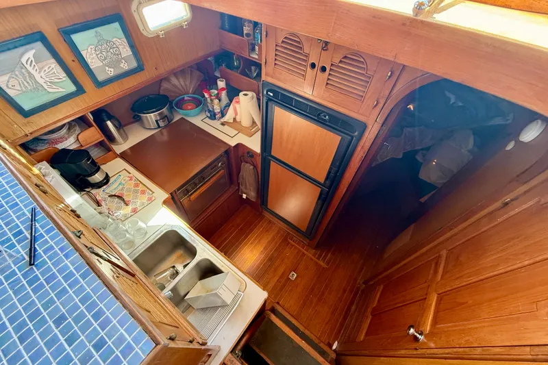 Slide: The Image of 1981 Kha Shing Sundeck ACMY yacht kitchen with wooden cabinetry and modern appliances. - 12