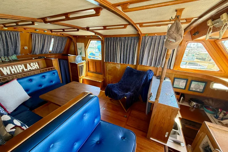 Slide: The Image of Interior of 1981 Kha Shing Sundeck ACMY yacht with blue seating and wooden accents. - 2