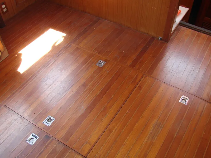 Slide: The Image of Wooden floor with recessed metal handles in a boat, illuminated by sunlight. - 46