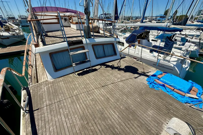 Slide: The Image of 1981 Kha Shing Sundeck ACMY yacht docked at marina, featuring spacious wooden deck. - 49