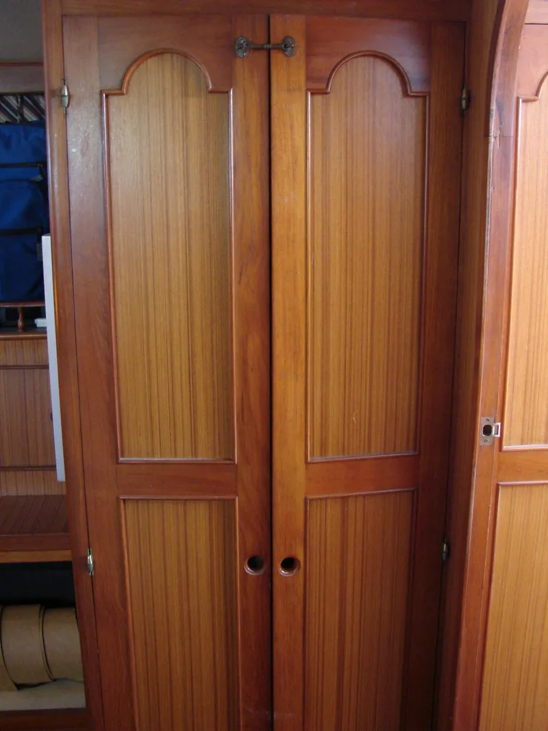 Slide: The Image of Wooden doors inside a yacht, featuring decorative panels and a simple latch. - 27