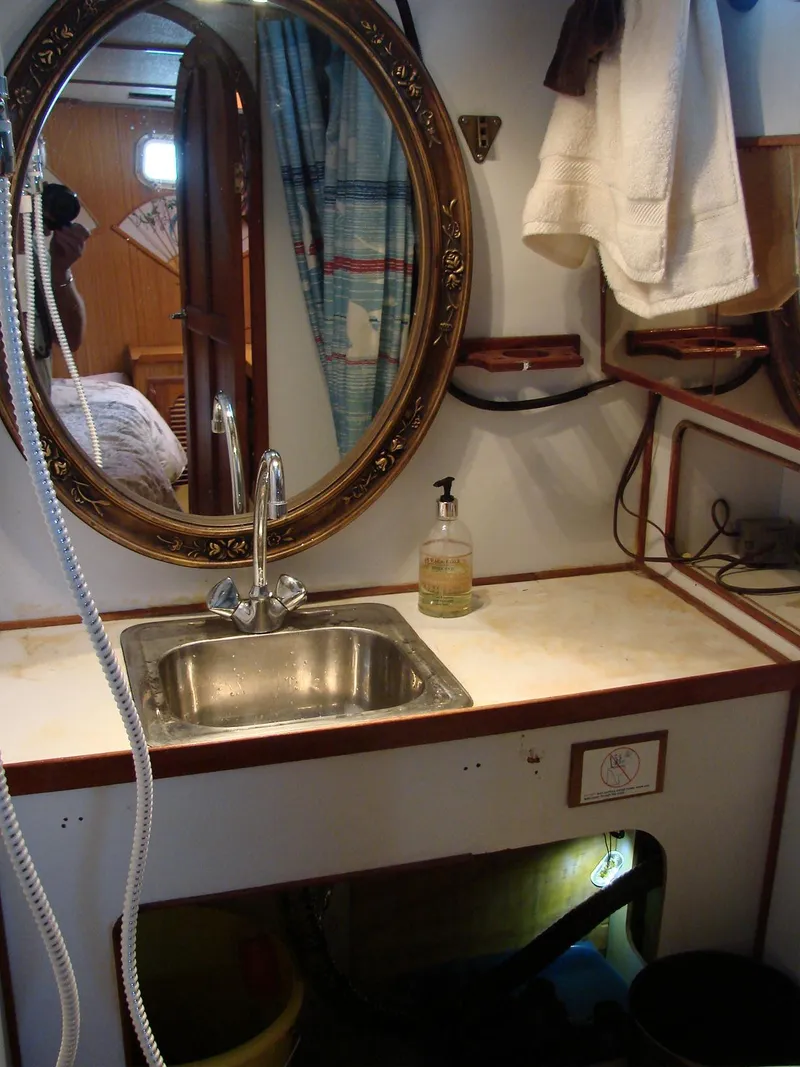 Slide: The Image of An elegant bathroom with an oval mirror, sink, and towels aboard a yacht. - 25