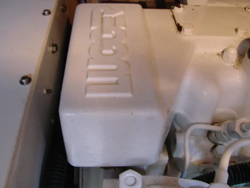 Slide: The Image of Close-up of a white engine block with embossed logo, surrounded by hoses and cables. - 41