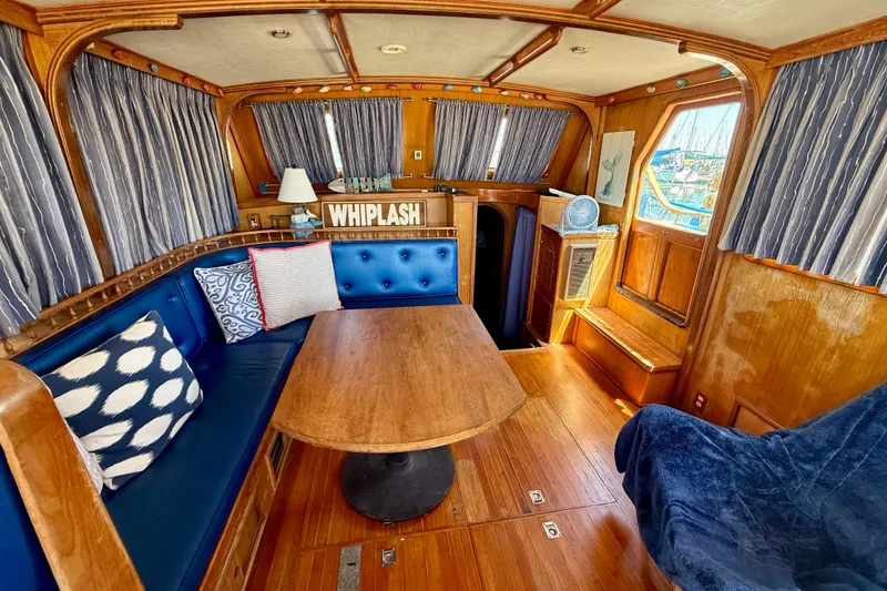 Slide: The Image of Interior of 1981 Kha Shing Sundeck ACMY yacht with wooden decor and blue seating. - 3