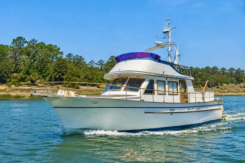 Slide: The Image of 1981 Kha Shing Sundeck ACMY yacht cruising on a scenic waterway. - 1