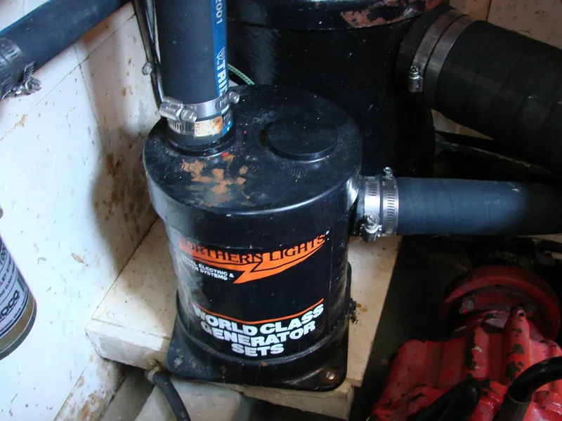 Slide: The Image of A generator in a boat engine room with hoses and cables. - 34