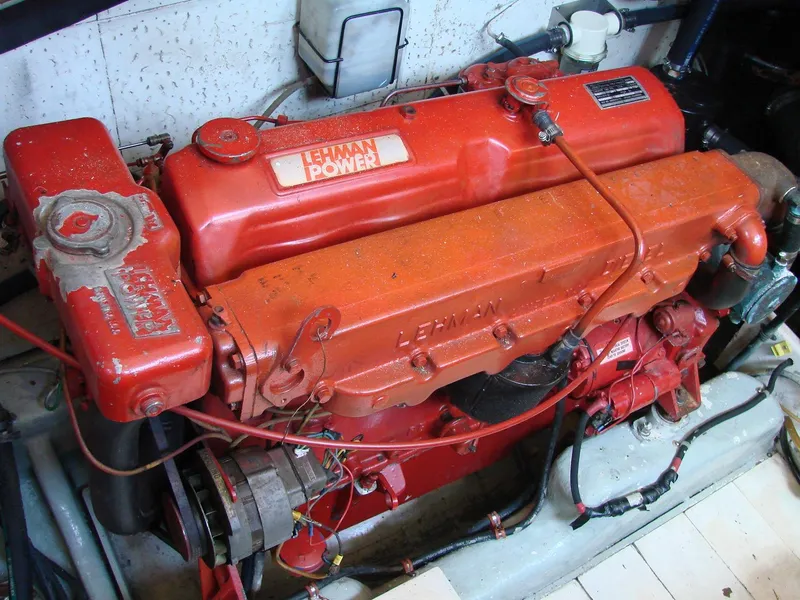 Slide: The Image of A red Lehman engine in a boat, surrounded by cables and hoses. - 33