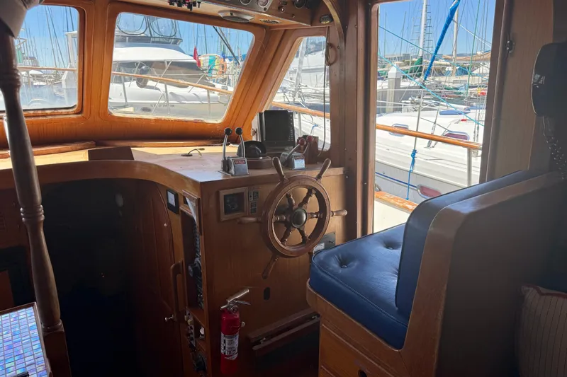 Slide: The Image of 1981 Kha Shing Sundeck ACMY yacht interior with wooden helm and marina view. - 6