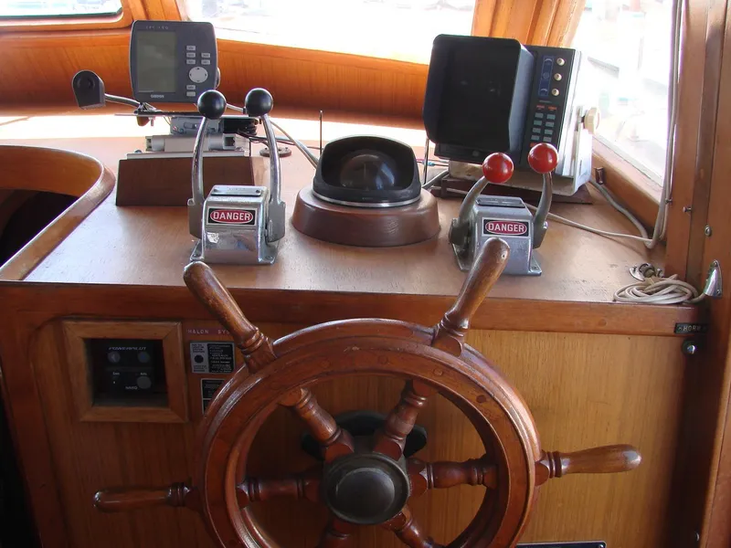 Slide: The Image of The image shows the helm of a 1981 Kha Shing Sundeck ACMY with a wooden steering wheel. - 9