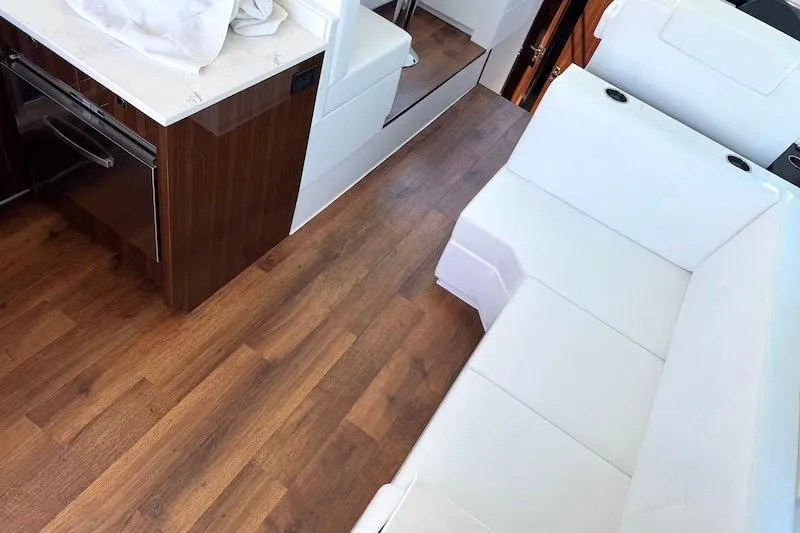 Slide: The Image of Interior of 2023 Cruisers Yachts 50 Cantius with white seating and wood flooring. - 25