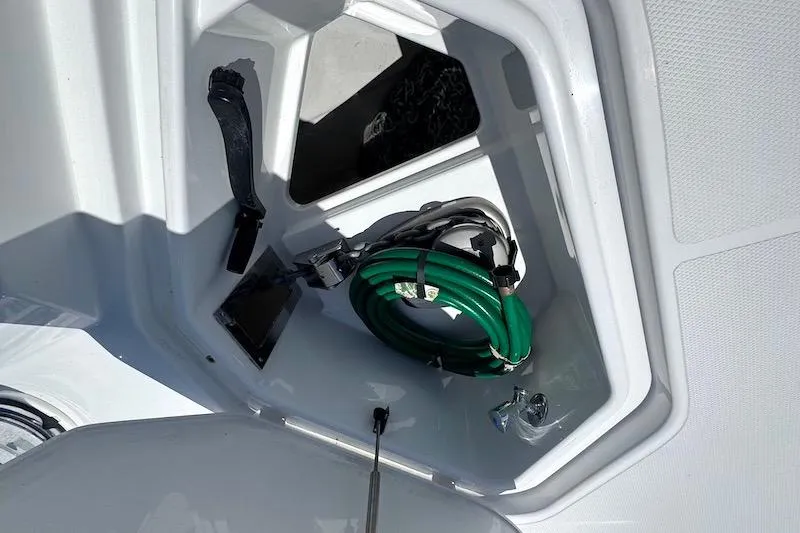 Slide: The Image of Storage compartment on 2023 Cruisers Yachts 50 Cantius with coiled green hose. - 15