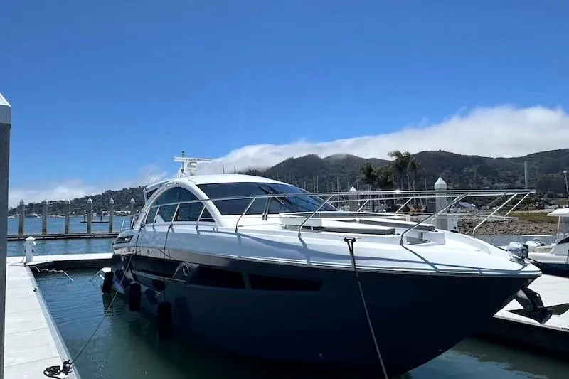 Slide: The Image of 2023 Cruisers Yachts 50 Cantius docked at a marina with scenic mountain backdrop. - 6