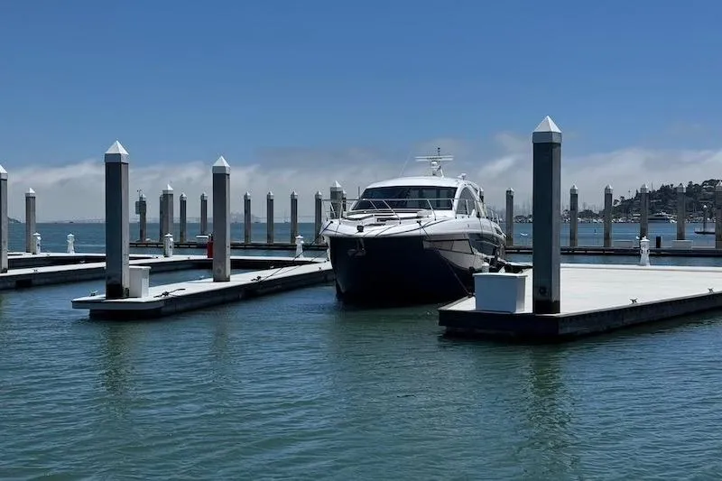 Slide: The Image of 2023 Cruisers Yachts 50 Cantius docked at a marina under clear blue skies. - 2