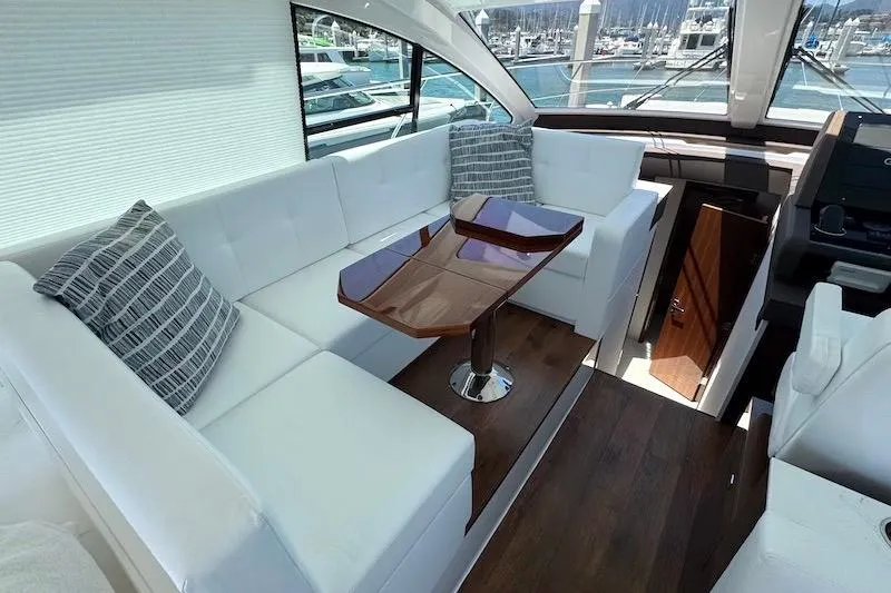 Slide: The Image of Luxurious interior of 2023 Cruisers Yachts 50 Cantius with white seating and wooden table. - 22
