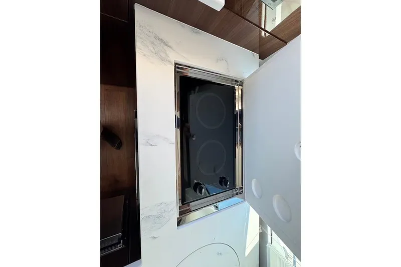 Slide: The Image of Modern kitchen stove on 2023 Cruisers Yachts 50 Cantius, featuring sleek design and marble countertop. - 20