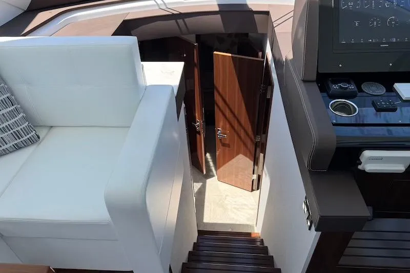 Slide: The Image of 2023 Cruisers Yachts 50 Cantius interior with stairs, helm, and seating area. - 30
