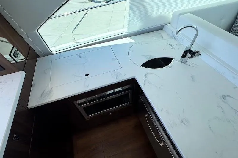 Slide: The Image of Modern kitchen area in 2023 Cruisers Yachts 50 Cantius with sleek countertops and stainless steel fixtures. - 21