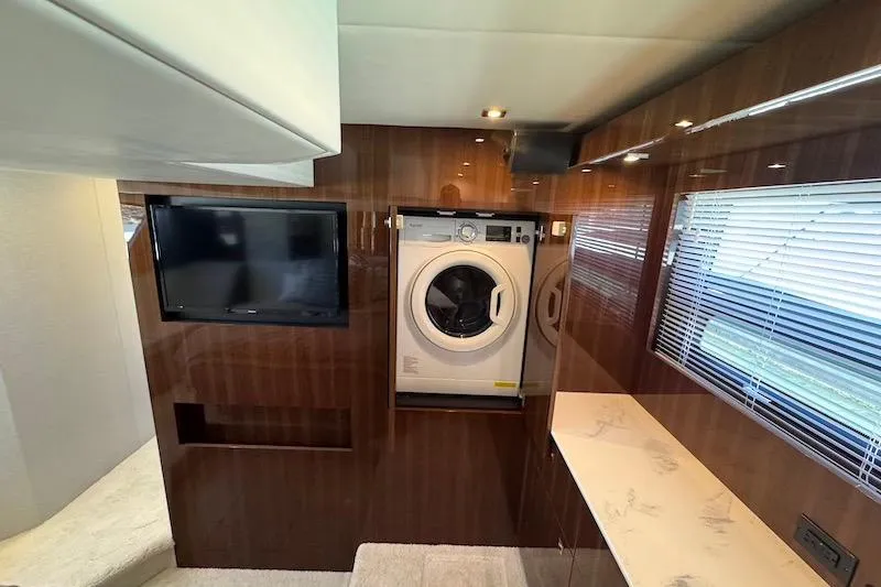 Slide: The Image of Interior of 2023 Cruisers Yachts 50 Cantius with washer, TV, and wood paneling. - 57