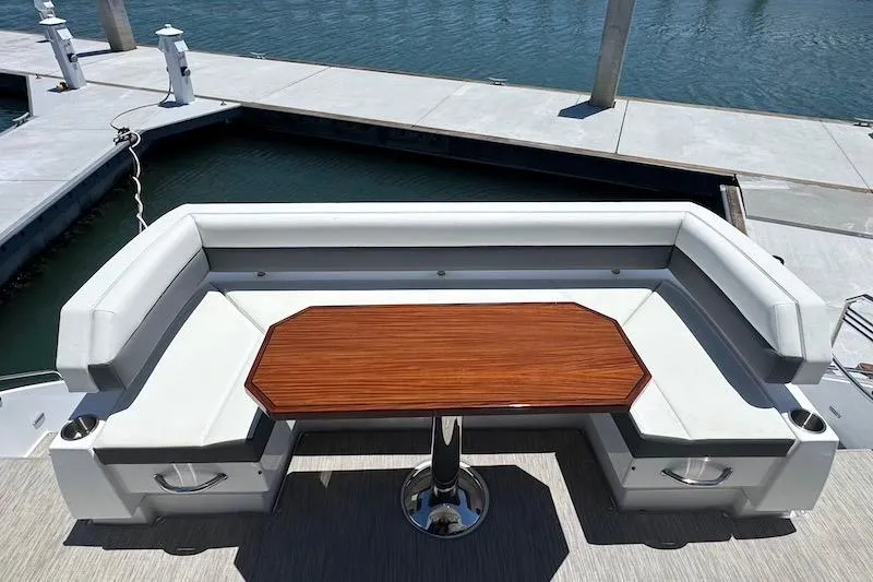Slide: The Image of Luxury seating area on 2023 Cruisers Yachts 50 Cantius, featuring elegant wood table. - 7
