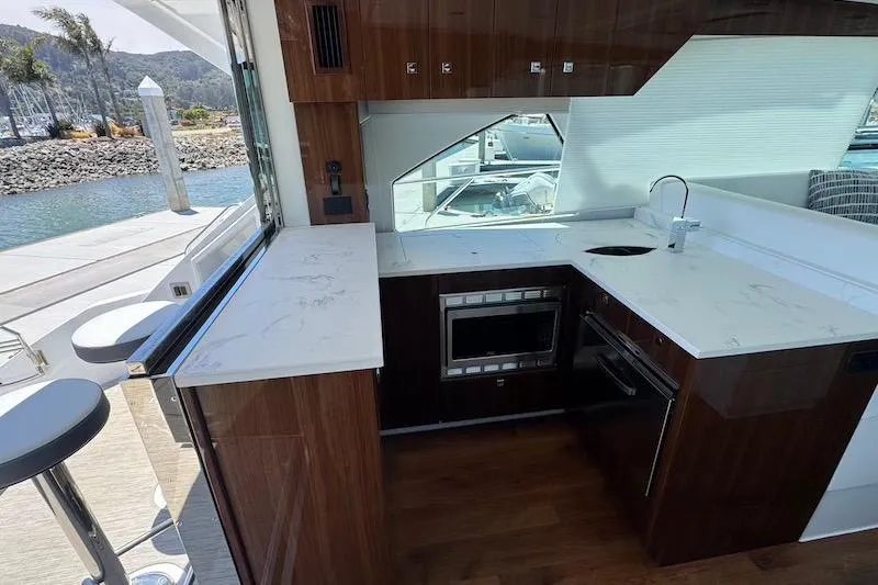 Slide: The Image of Luxurious 2023 Cruisers Yachts 50 Cantius kitchen with modern appliances and elegant wood finish. - 18