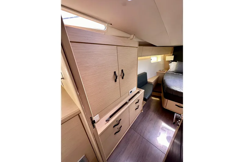 Slide: The Image of Luxurious interior of 2018 Jeanneau 54 yacht with modern wood cabinetry and cozy sleeping area. - 97