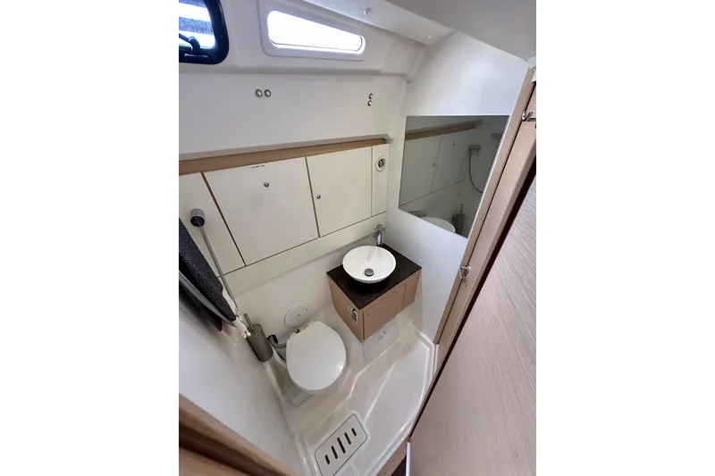 Slide: The Image of Compact bathroom in 2018 Jeanneau 54 yacht with sink, toilet, and storage cabinets. - 68