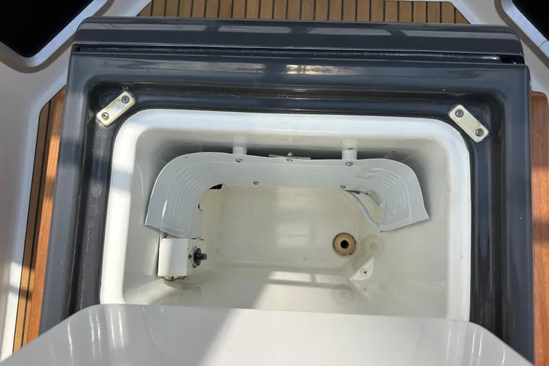 Slide: The Image of Open storage compartment on 2018 Jeanneau 54 yacht, featuring white interior and metal hinges. - 59