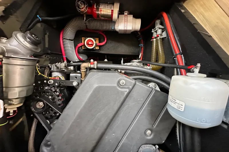 Slide: The Image of Engine compartment of a 2018 Jeanneau 54 sailboat, showcasing mechanical components and wiring. - 114